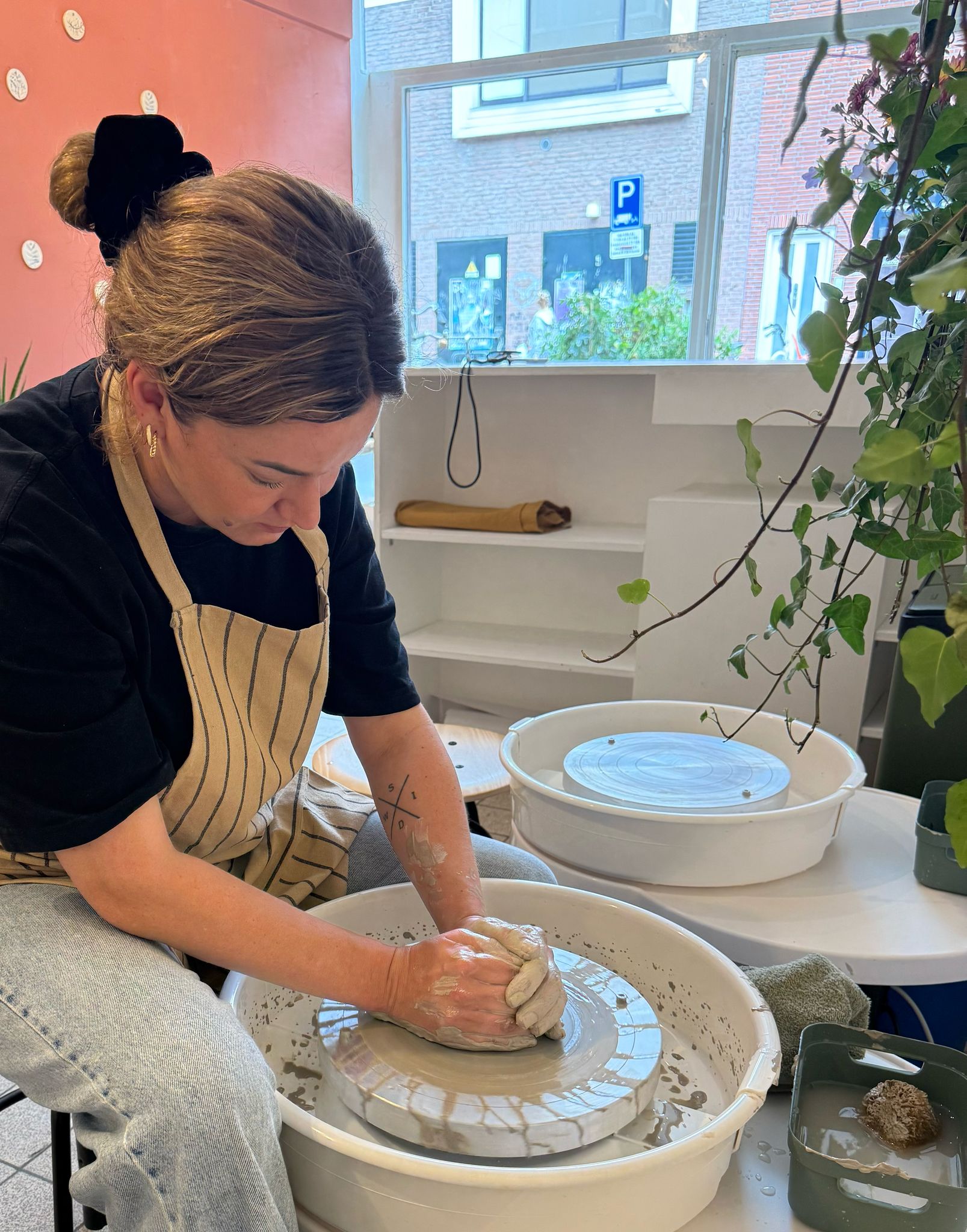 Een vrouw potten aan het bakken in Atelier Potters